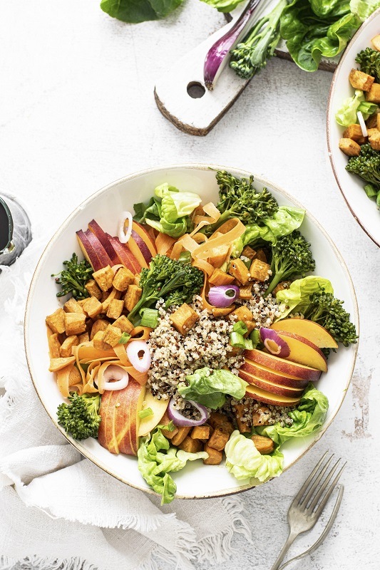 Sweet potato buddha bowl on white table flat lay